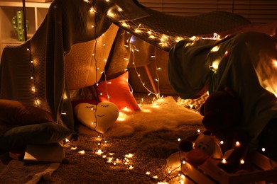 Beautiful play tent decorated with festive lights at home