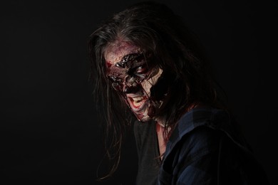 Scary zombie on dark background. Halloween monster