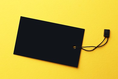 Tag with space for text on yellow background, top view