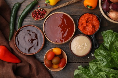 Photo of Different marinades and products on wooden table, flat lay