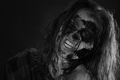 Scary zombie on dark background, black and white effect. Halloween monster