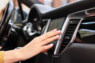 Photo of Woman checking air conditioner in her car, closeup