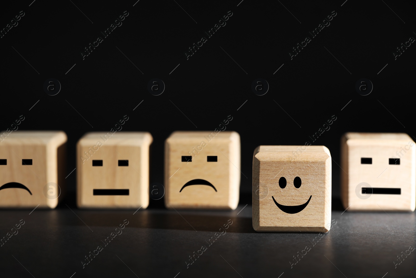 Photo of Choice concept. Wooden cubes with different emoticons on black background