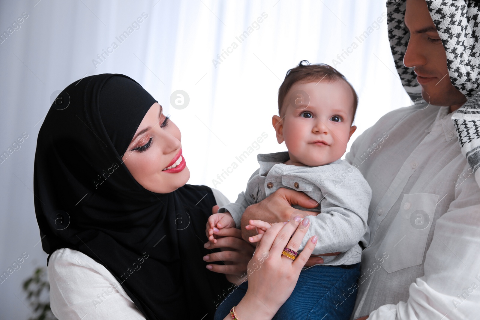 Photo of Happy Muslim family with little son indoors