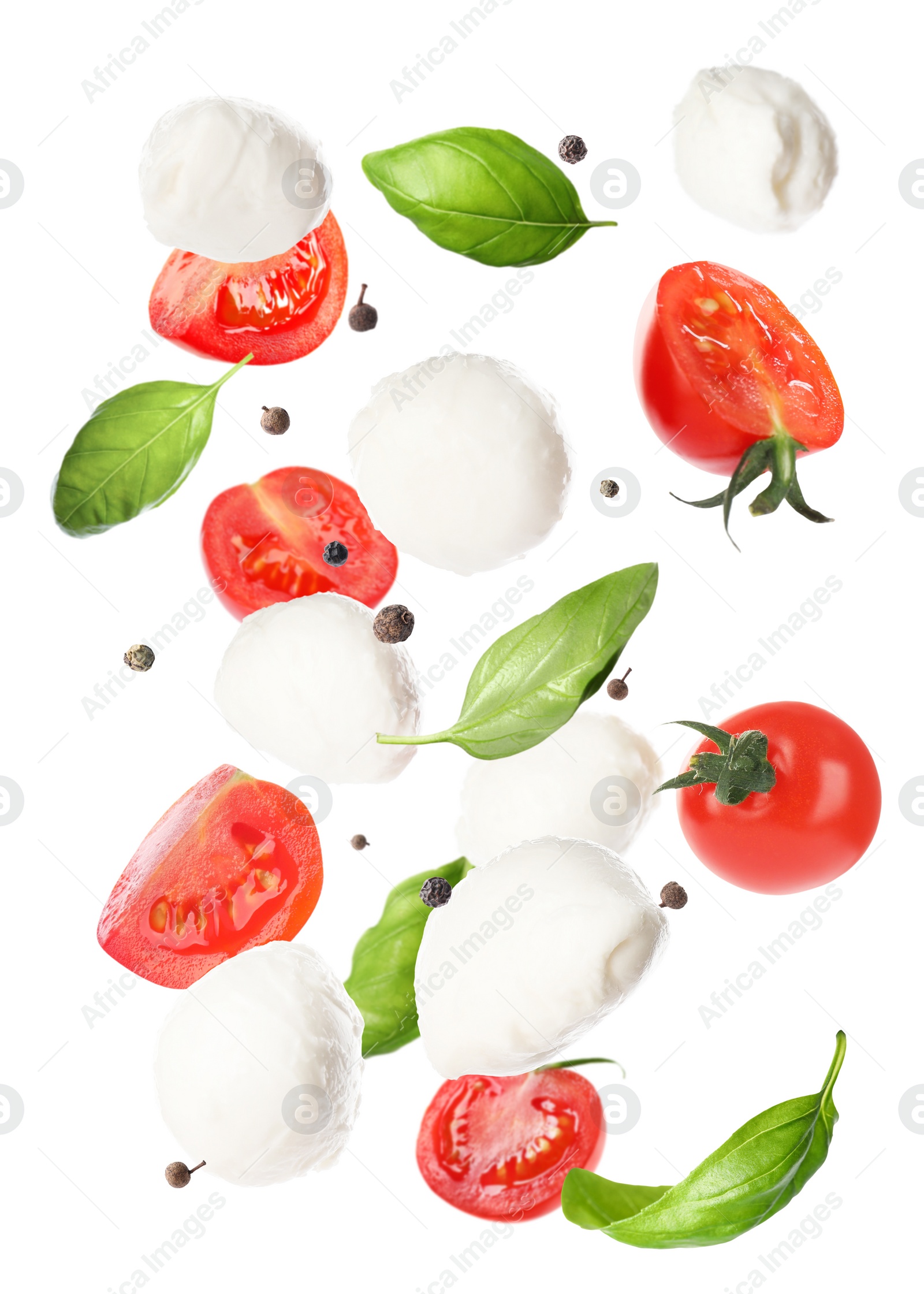 Image of Mozzarella cheese balls, tomatoes, basil leaves and peppercorns for caprese salad flying on white background