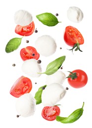 Mozzarella cheese balls, tomatoes, basil leaves and peppercorns for caprese salad flying on white background