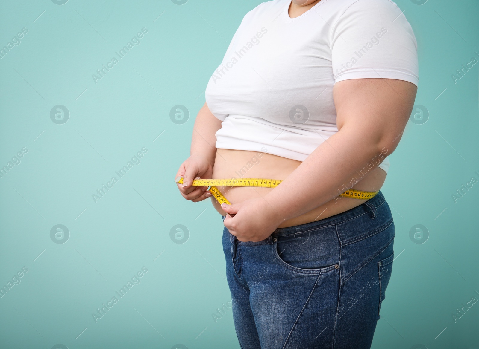 Photo of Overweight woman with measuring tape on color background