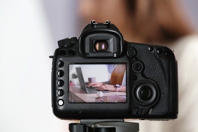 Photo of Photo of blogger at workplace on camera screen, closeup