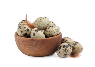 Photo of Wooden bowl, quail eggs and feathers on white background