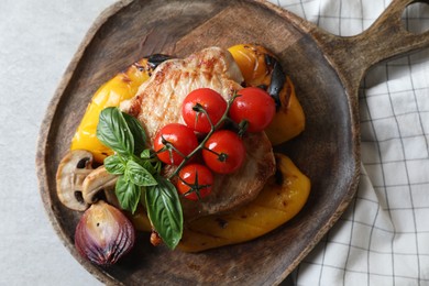 Serving board with tasty grilled meat and vegetables on light table, top view