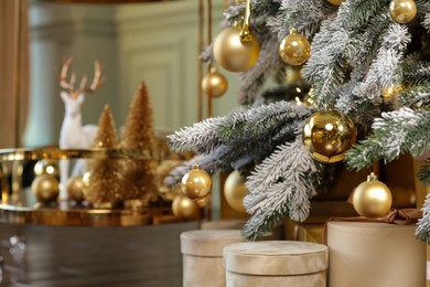 Many gift boxes under decorated Christmas tree at home, closeup