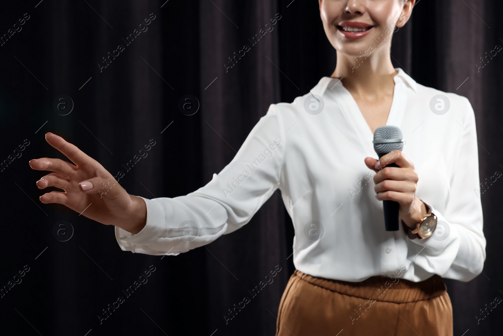 Photo of Motivational speaker with microphone performing on stage, closeup 