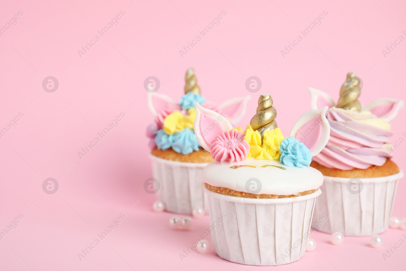 Photo of Cute sweet unicorn cupcakes on pink background. Space for text