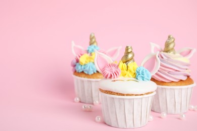 Cute sweet unicorn cupcakes on pink background. Space for text