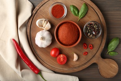 Photo of Red curry paste and ingredients on wooden table, flat lay