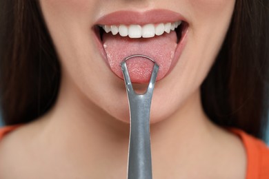 Photo of Woman brushing her tongue with cleaner, closeup