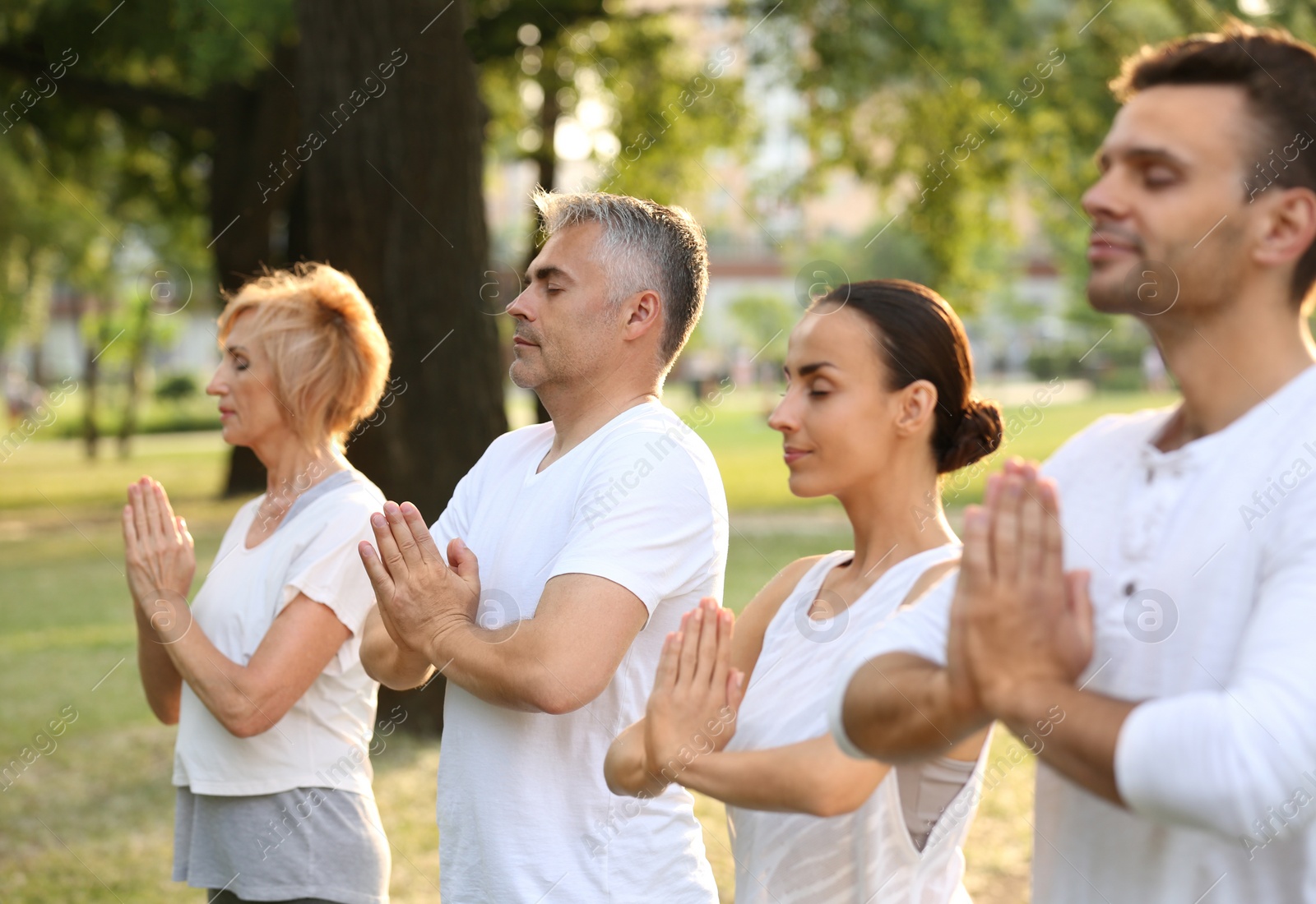 Photo of People practicing yoga in park at morning