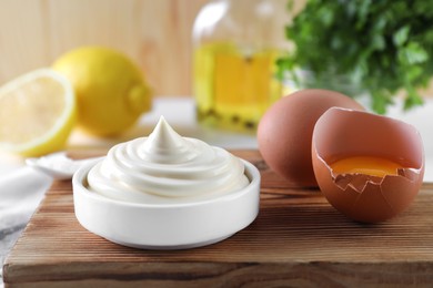 Photo of Fresh mayonnaise sauce in bowl and ingredients on table, closeup