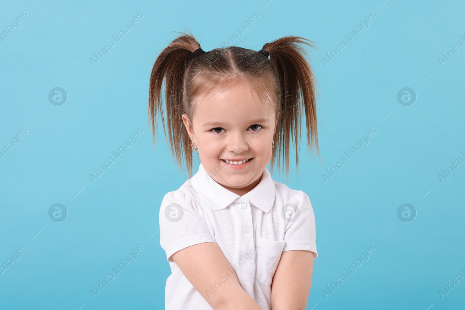 Photo of Portrait of happy little girl on light blue background