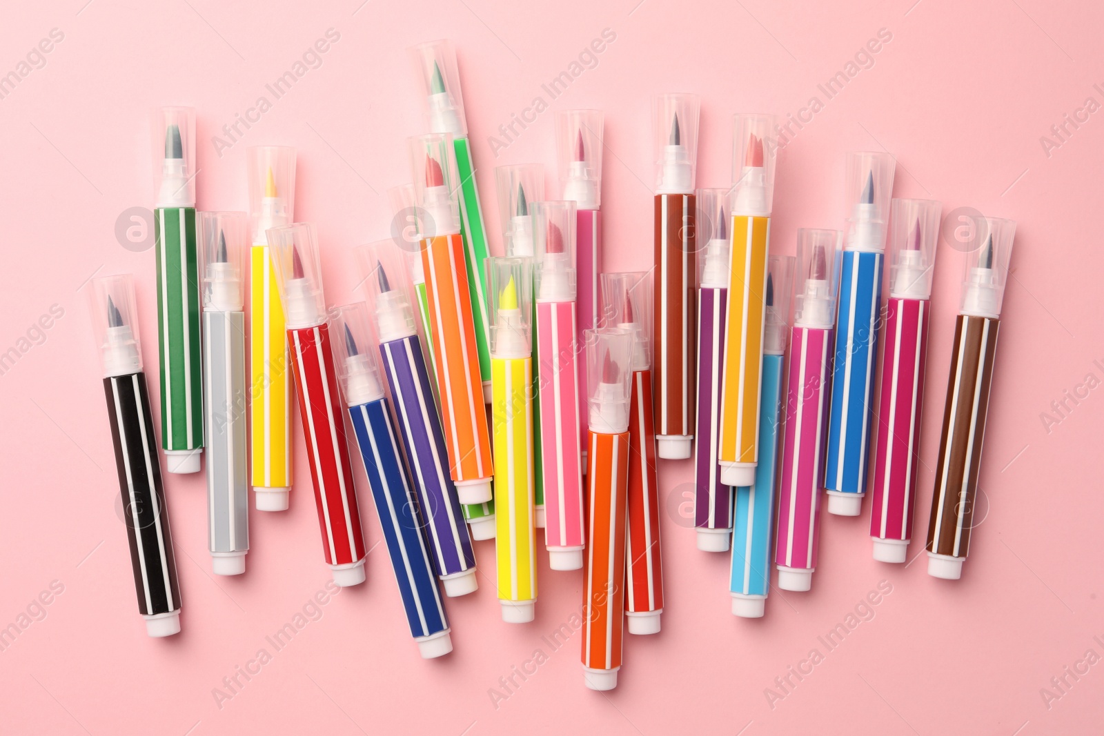 Photo of Many bright markers on pink background, flat lay