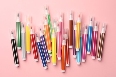 Many bright markers on pink background, flat lay