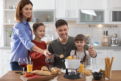 Happy family enjoying fondue dinner at home