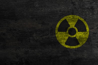 Image of Radioactive sign on black stone wall, space for text. Hazard symbol