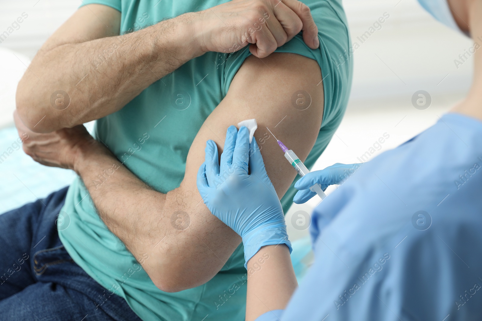 Photo of Doctor giving hepatitis vaccine to patient in clinic, closeup