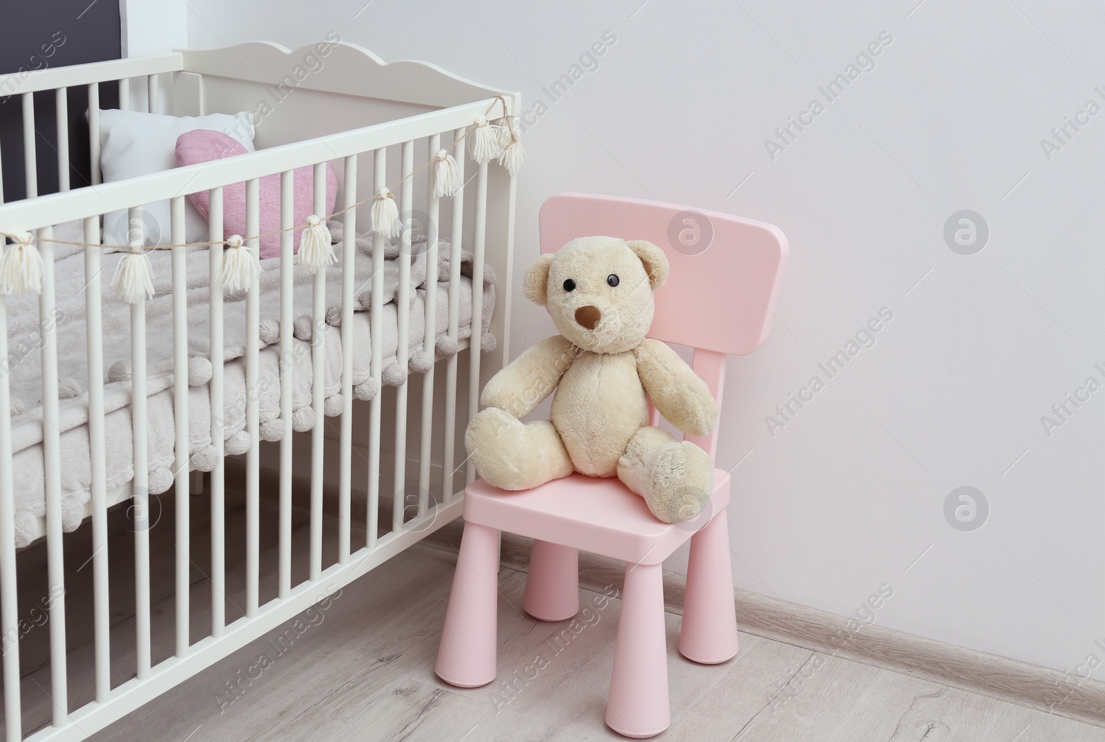 Photo of Stylish baby room interior with comfortable crib