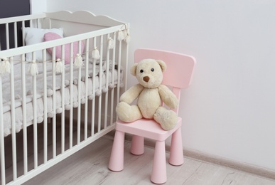 Photo of Stylish baby room interior with comfortable crib