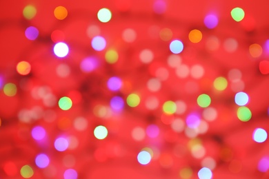 Photo of Blurred view of glowing Christmas lights on color background, top view