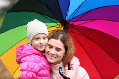 Photo of Mother and daughter with umbrella outdoors on autumn rainy day