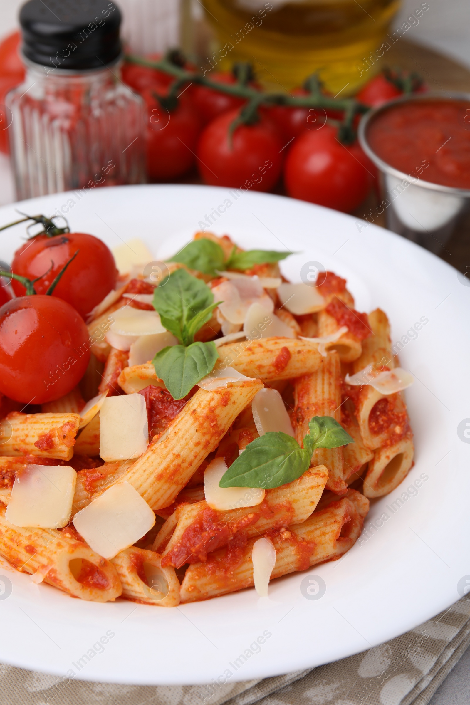 Photo of Tasty pasta with tomato sauce, cheese and basil on table