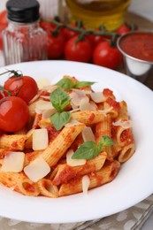 Tasty pasta with tomato sauce, cheese and basil on table