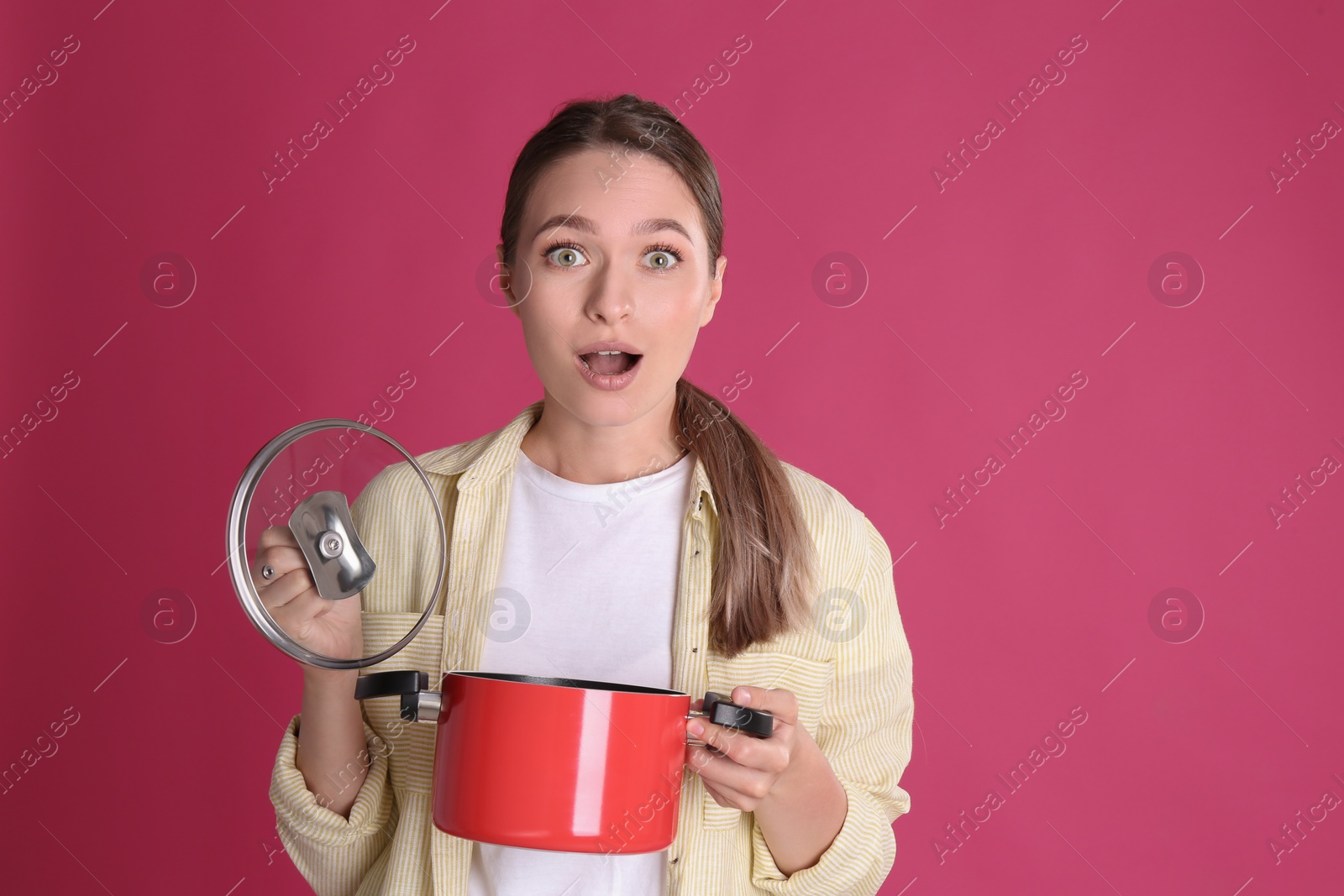 Photo of Surprised woman with pot on crimson background