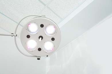 Photo of Powerful surgical lamps in modern operating room. Space for text
