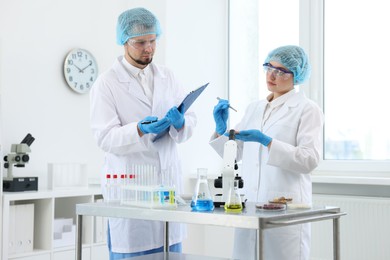 Photo of Quality control. Food inspectors checking safety of products in laboratory