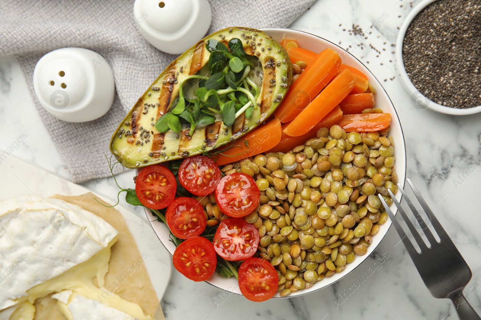 Photo of Delicious lentil bowl with avocado, tomatoes and carrots on white marble table, flat lay