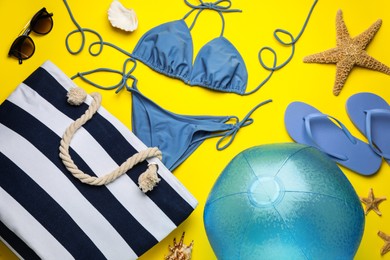 Photo of Flat lay composition with ball and beach objects on yellow background
