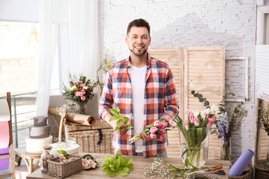 Male decorator creating beautiful bouquet at table