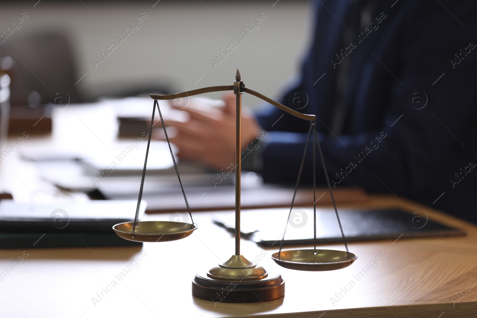 Photo of Scales of justice and blurred lawyer on background