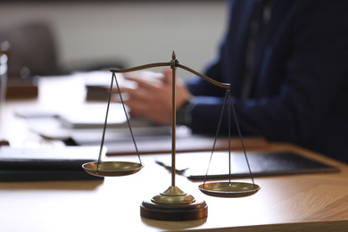 Photo of Scales of justice and blurred lawyer on background