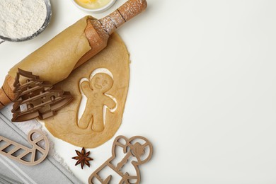 Photo of Christmas treat. Flat lay composition with cookie cutters and ingredients on white table, space for text