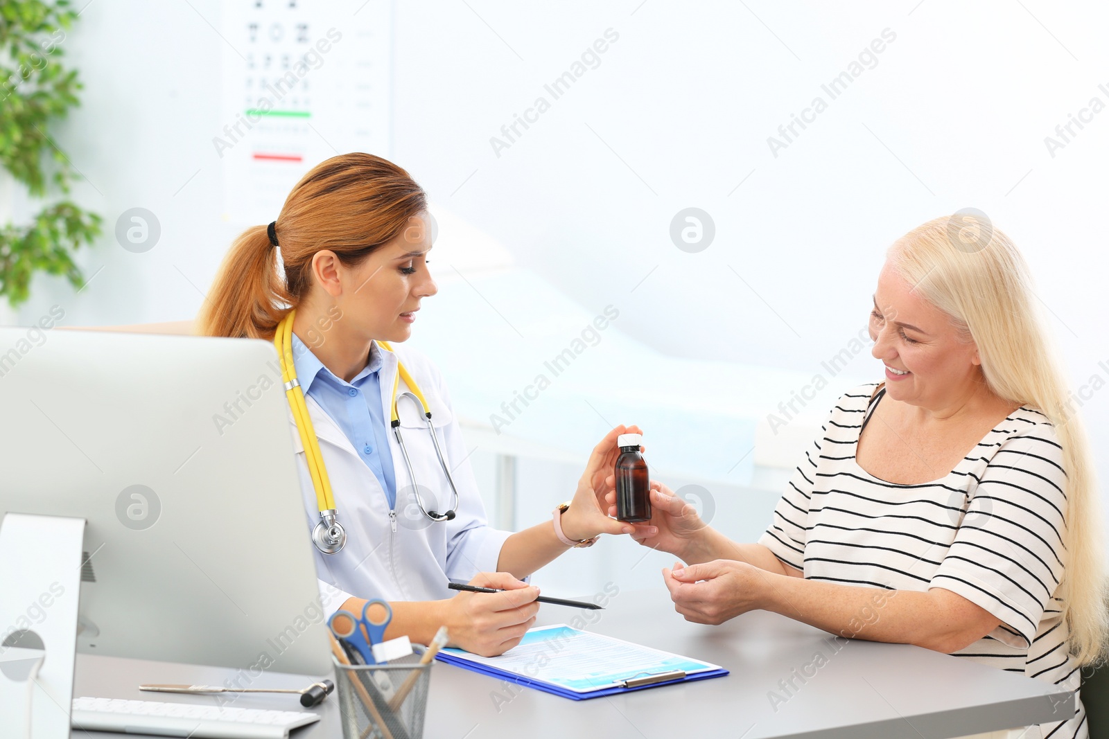Photo of Doctor giving medication to mature patient in hospital