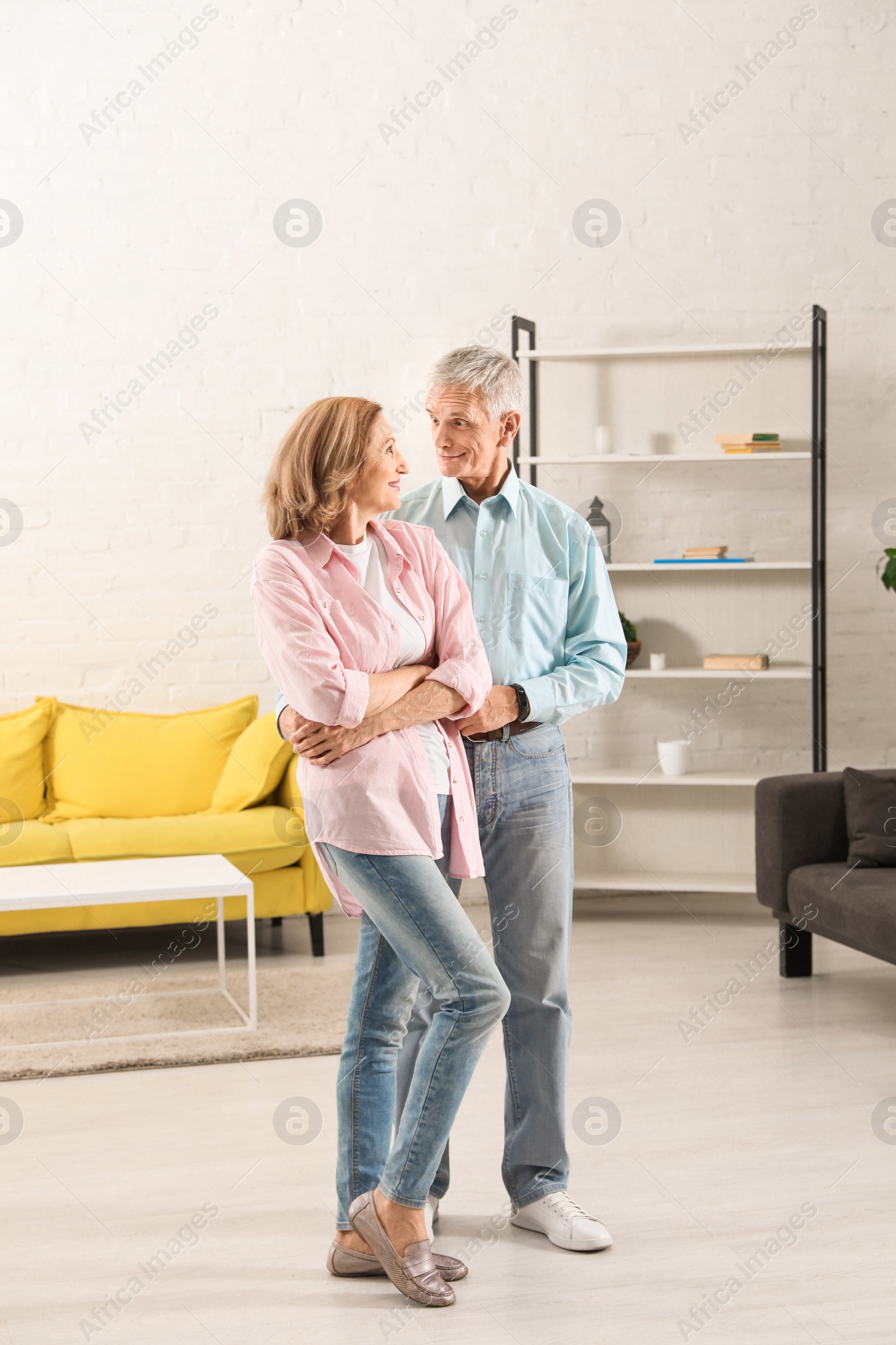 Photo of Happy senior couple dancing together in living room