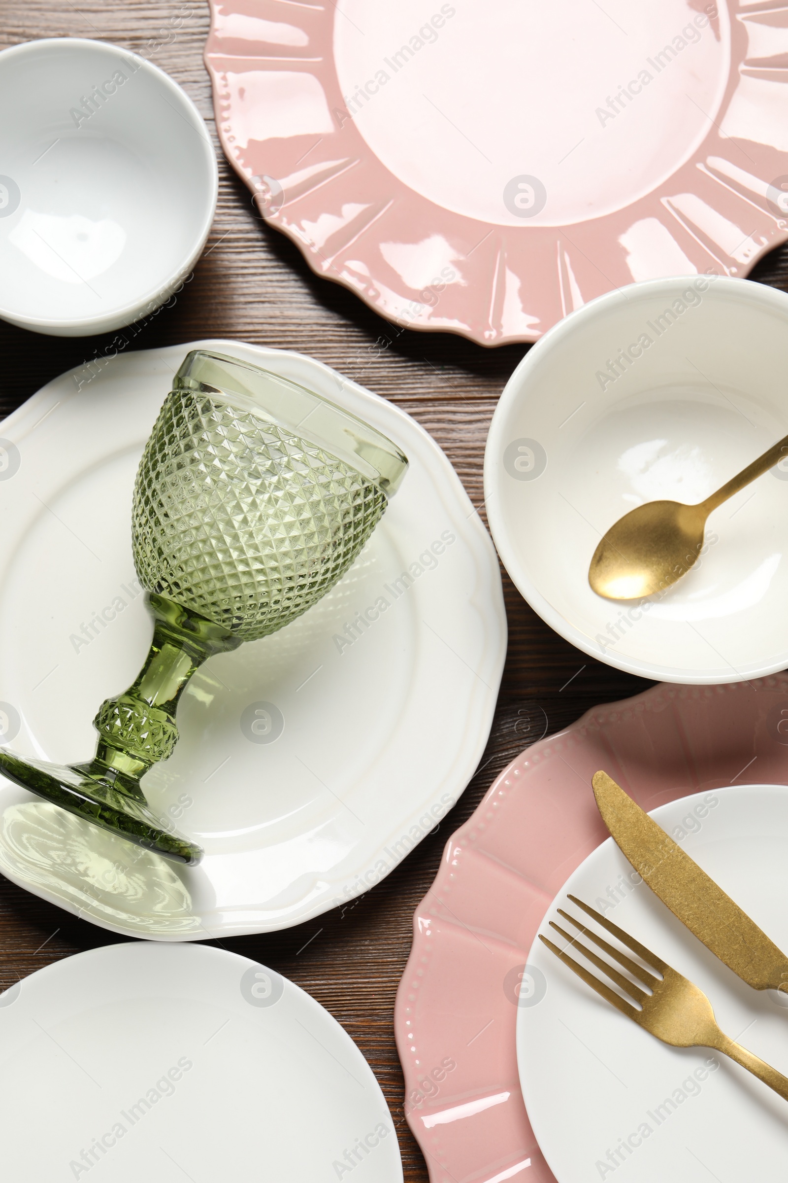 Photo of Beautiful ceramic dishware, glass and cutlery on wooden table, flat lay