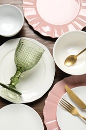 Photo of Beautiful ceramic dishware, glass and cutlery on wooden table, flat lay