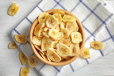 Photo of Wooden bowl with sweet banana slices on table, top view. Dried fruit as healthy snack