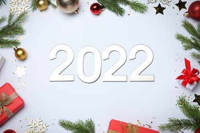 Photo of Flat lay composition with number 2022 and festive decor on white background. Happy New Year