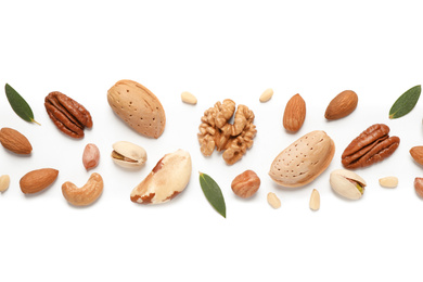 Different delicious nuts on white background, flat lay